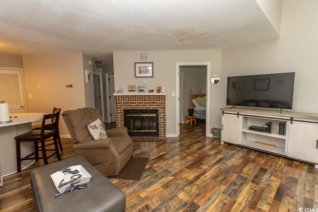 living room with a fireplace, a textured ceiling, and dark hardwood / wood-style floors