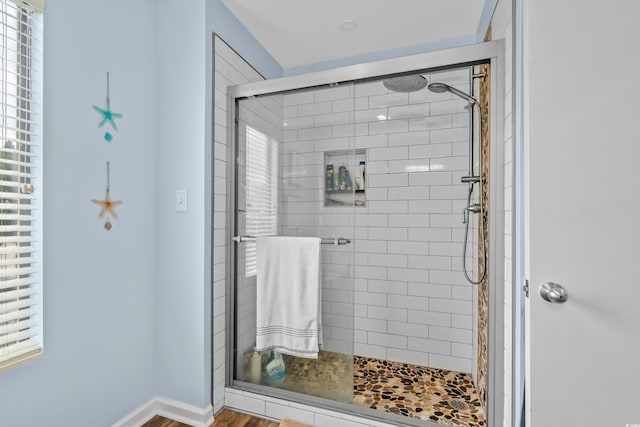 full bathroom featuring a tile shower and baseboards