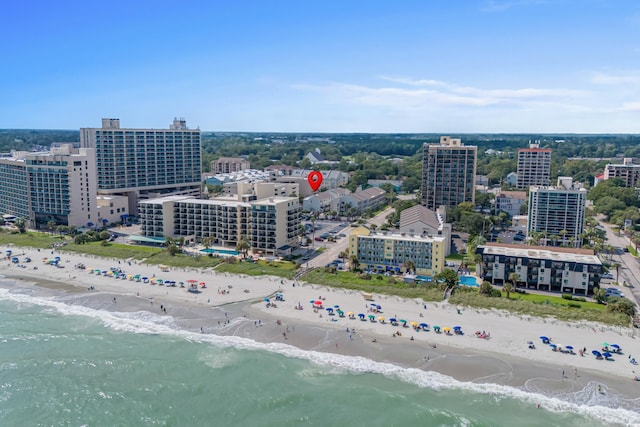 drone / aerial view featuring a city view, a water view, and a beach view