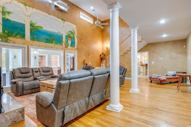 living room featuring high vaulted ceiling, light hardwood / wood-style floors, ceiling fan, and ornate columns