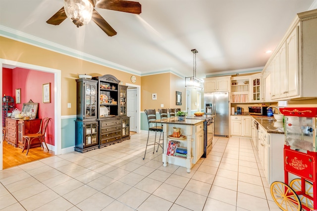 kitchen featuring ceiling fan, hanging light fixtures, a kitchen island, stainless steel appliances, and crown molding