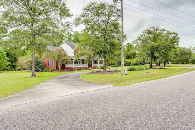 5414 Hampton Rd, Conway, SC 29527 - obstructed view of property with driveway, covered porch, a front lawn, and view of scattered trees