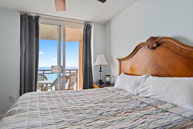 bedroom featuring access to outside, a textured ceiling, ceiling fan, and multiple windows