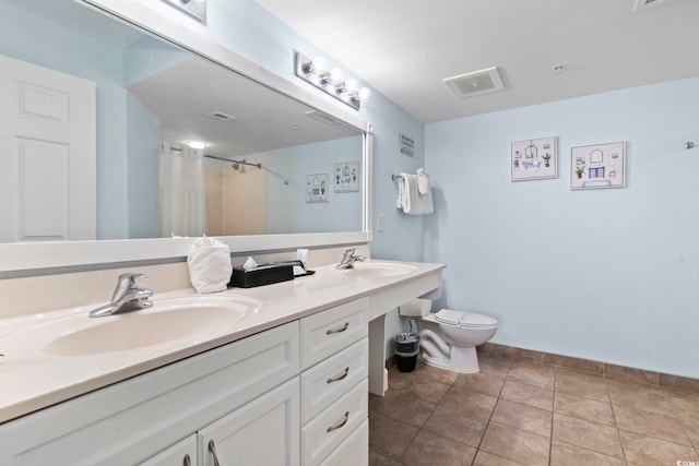 bathroom featuring tile patterned floors, double vanity, and toilet