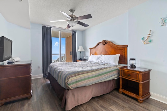 bedroom with ceiling fan, dark hardwood / wood-style flooring, access to outside, and a textured ceiling