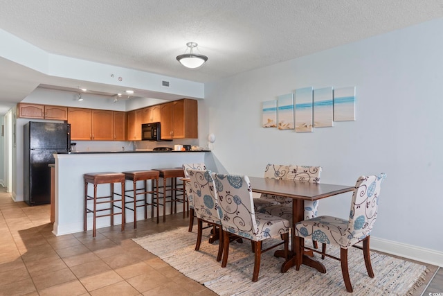 tiled dining room with a textured ceiling