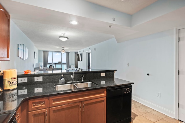 kitchen with a textured ceiling, light tile patterned floors, dishwasher, sink, and dark stone counters