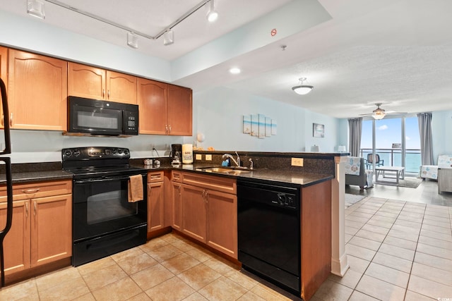 1321 S Ocean Blvd Unit 606, North Myrtle Beach, SC 29582 - kitchen with black appliances, a peninsula, light tile patterned flooring, and dark stone countertops