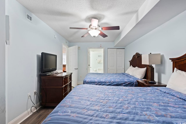 bedroom with a closet, a textured ceiling, dark wood-type flooring, and ceiling fan