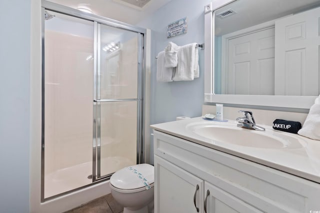 bathroom featuring a shower with shower door, vanity, tile patterned floors, and toilet