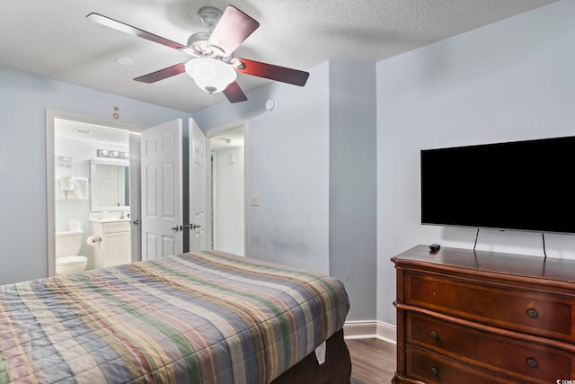 bedroom with ceiling fan, a textured ceiling, ensuite bathroom, and hardwood / wood-style floors