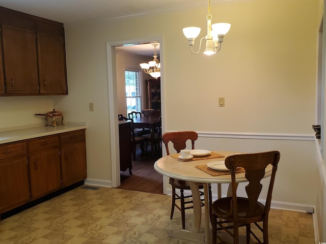 dining room with ornamental molding and an inviting chandelier