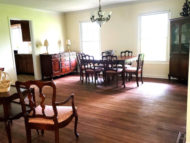 dining space featuring crown molding, plenty of natural light, dark hardwood / wood-style floors, and an inviting chandelier