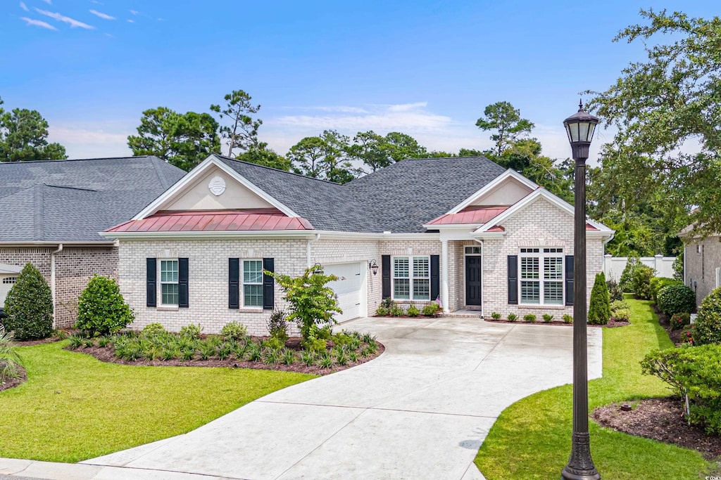 view of front of home with a front yard and a garage