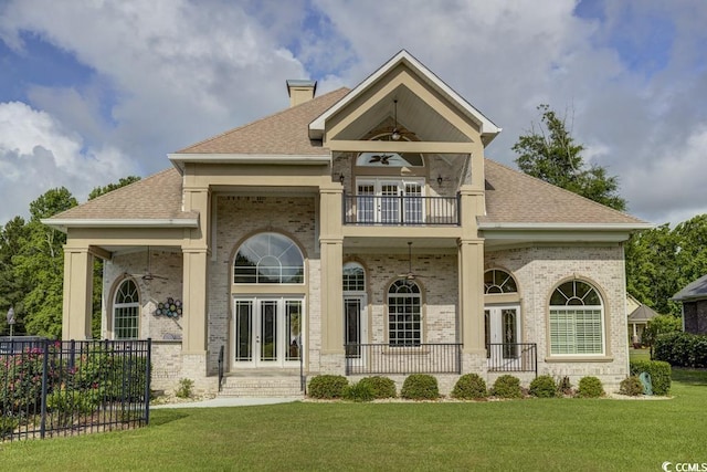 back of property featuring ceiling fan, a yard, french doors, and a balcony