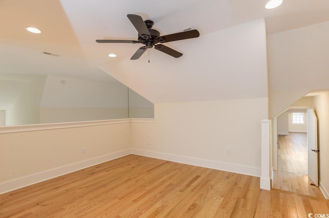 additional living space with wood-type flooring and vaulted ceiling