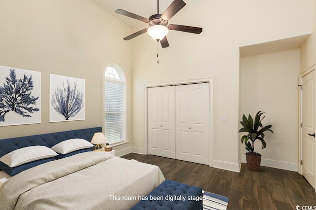 bedroom with dark wood-type flooring, ceiling fan, high vaulted ceiling, and a closet