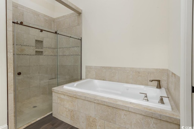 bathroom with hardwood / wood-style flooring and independent shower and bath