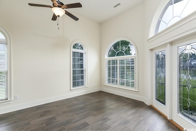 unfurnished sunroom featuring ceiling fan and a healthy amount of sunlight