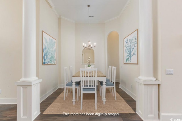 dining area with dark hardwood / wood-style flooring, ornamental molding, a chandelier, and ornate columns