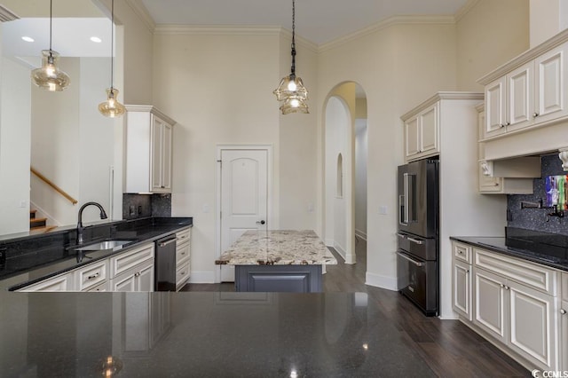 kitchen featuring appliances with stainless steel finishes, a kitchen island, sink, and hanging light fixtures