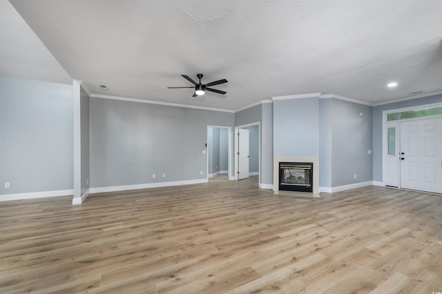 unfurnished living room with a textured ceiling, light hardwood / wood-style flooring, ceiling fan, and ornamental molding