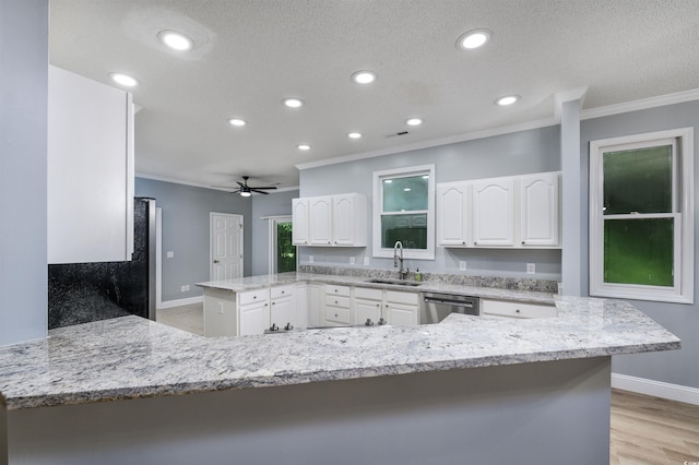 kitchen with dishwasher, kitchen peninsula, sink, light stone countertops, and white cabinetry