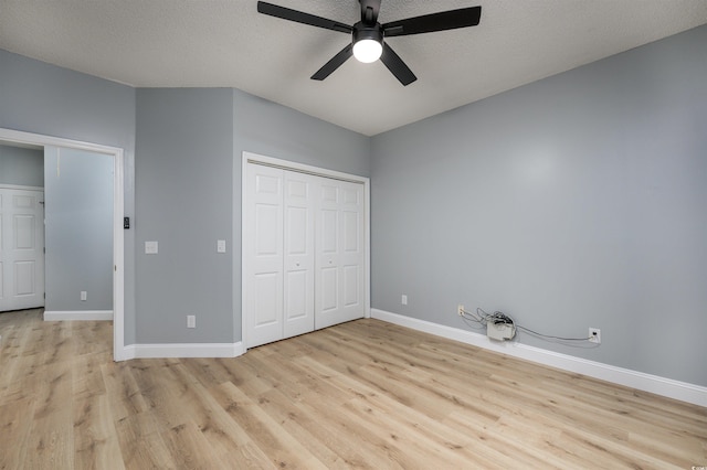 unfurnished bedroom with light wood-type flooring, a textured ceiling, and ceiling fan