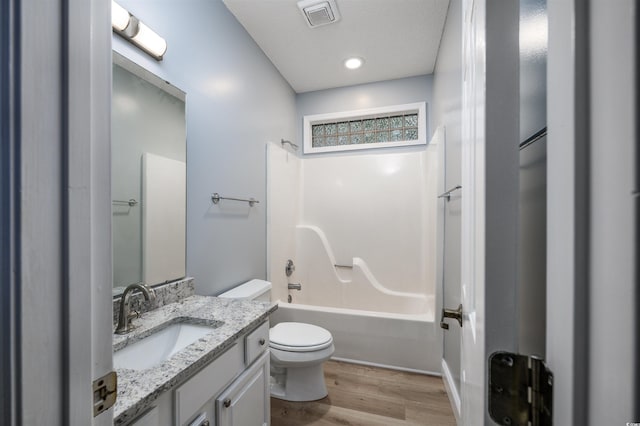 full bathroom with hardwood / wood-style floors, vanity, toilet, and shower / washtub combination