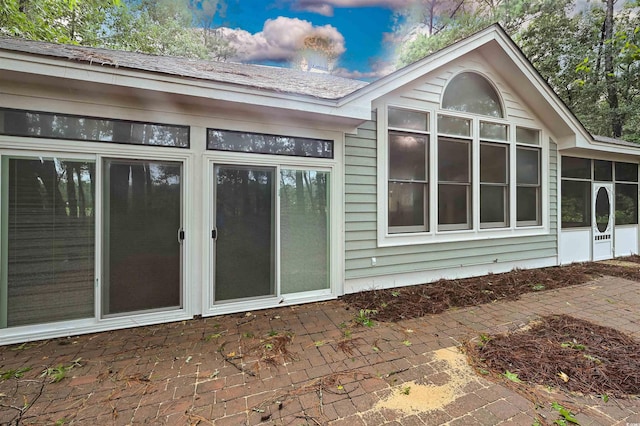 1237 Clipper Rd, North Myrtle Beach, SC 29582 - view of side of home with a sunroom, roof with shingles, and a patio
