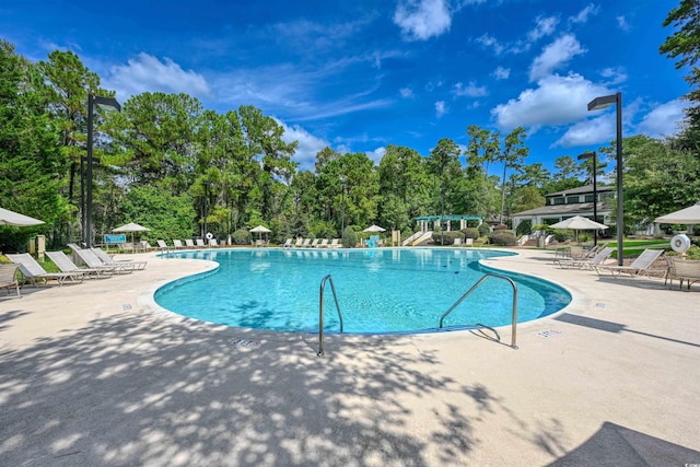 1237 Clipper Rd, North Myrtle Beach, SC 29582 - community pool featuring a patio area and view of wooded area