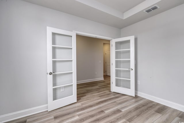 spare room with french doors and light hardwood / wood-style flooring