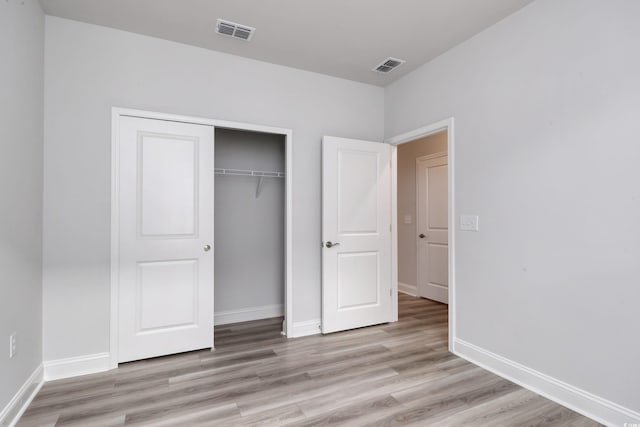 unfurnished bedroom with light hardwood / wood-style floors and a closet