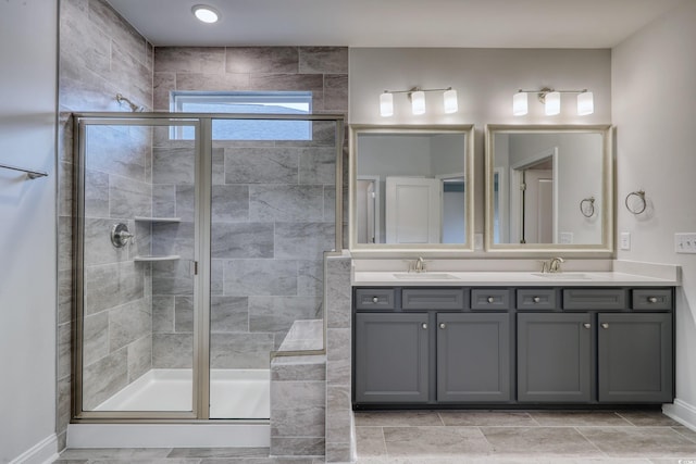 bathroom featuring a shower with door and vanity