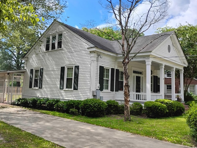 greek revival house featuring a front yard and a porch