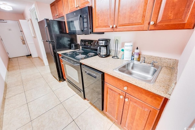 kitchen featuring sink, light tile patterned floors, and black appliances