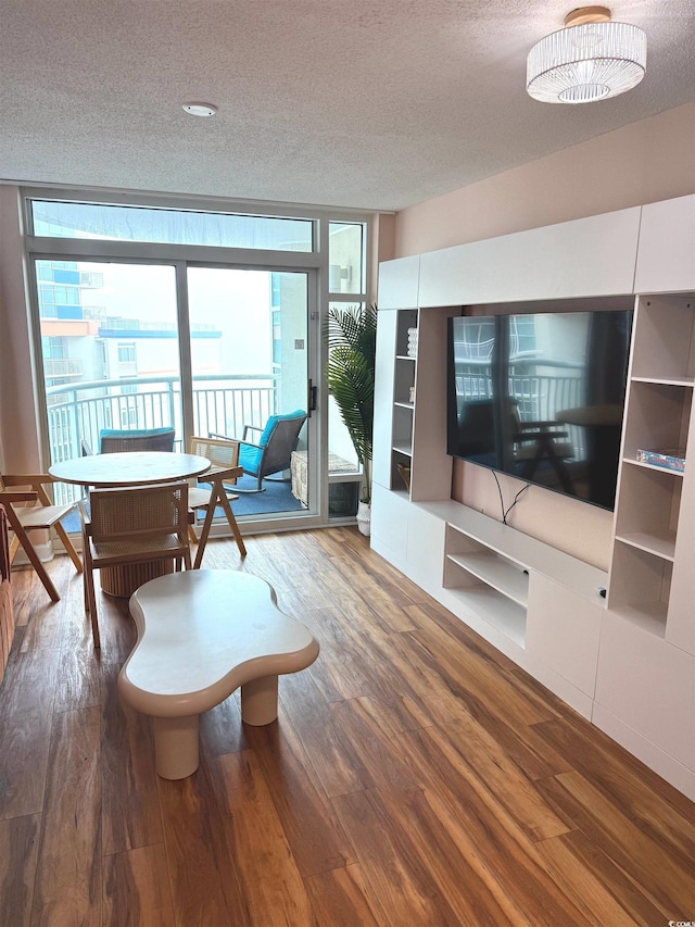 interior space with expansive windows, a textured ceiling, and hardwood / wood-style flooring