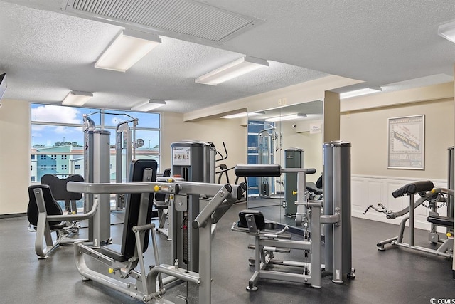 workout area with floor to ceiling windows and a textured ceiling