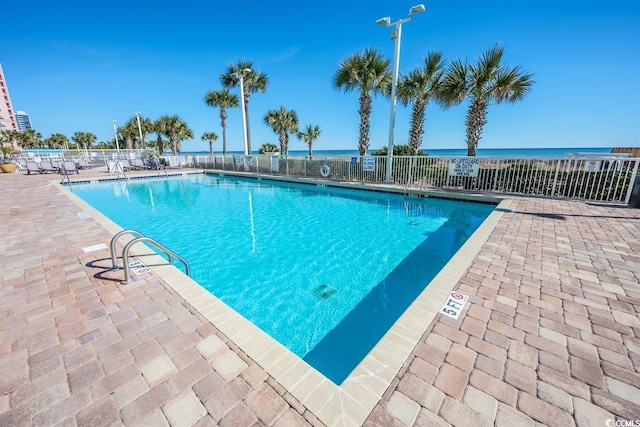 view of pool featuring a patio and a water view