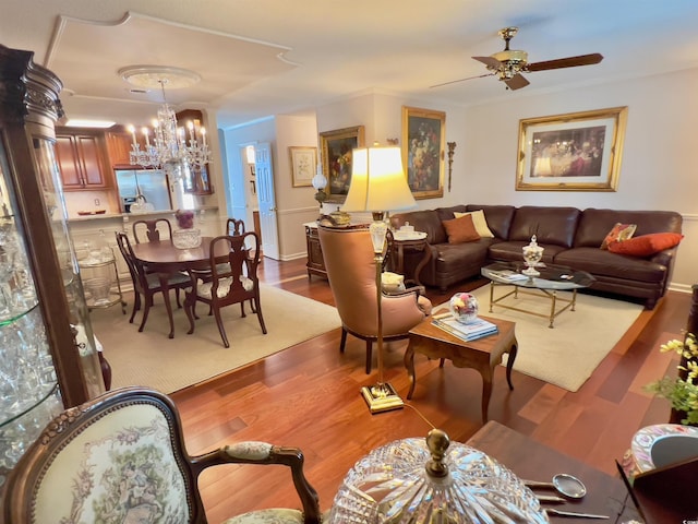 living area with wood finished floors and ceiling fan with notable chandelier