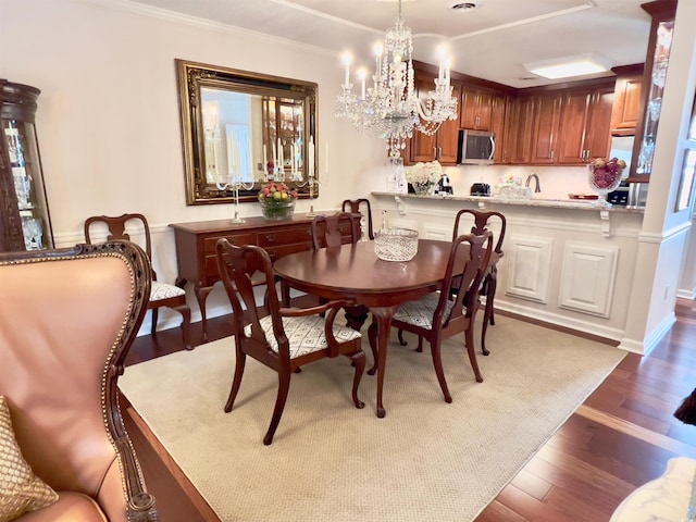 dining space with a notable chandelier, dark hardwood / wood-style flooring, and ornamental molding