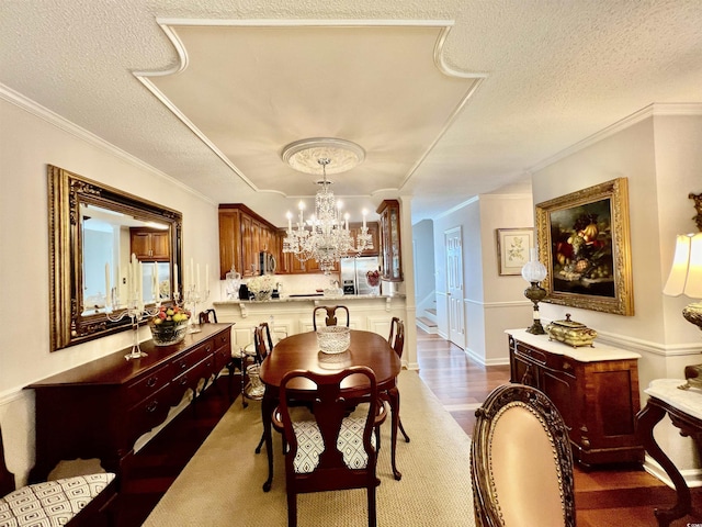 dining space with crown molding, a textured ceiling, and an inviting chandelier