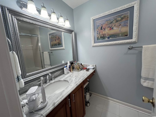 bathroom with walk in shower, vanity, and tile patterned floors