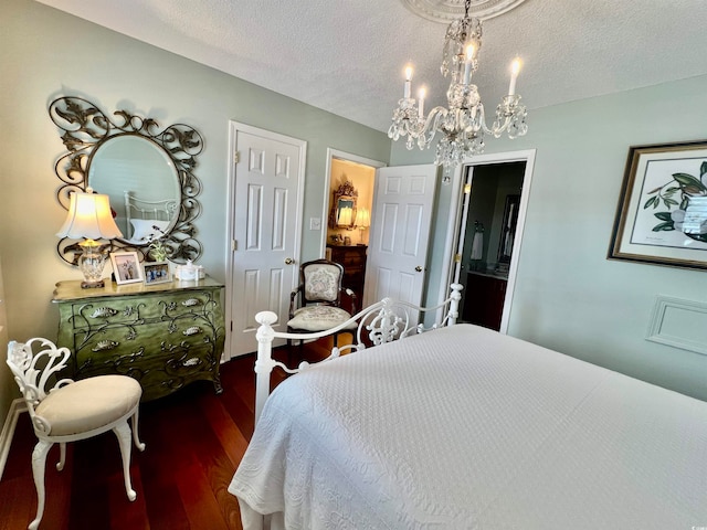 bedroom featuring dark hardwood / wood-style flooring, a notable chandelier, and a textured ceiling