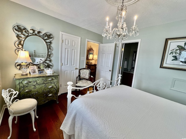 bedroom featuring a textured ceiling, wood finished floors, and a notable chandelier