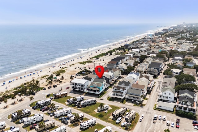 birds eye view of property featuring a water view and a beach view