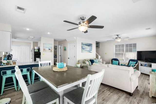 dining space with light hardwood / wood-style floors and ceiling fan