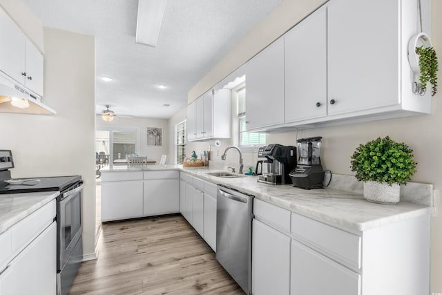 kitchen with sink, white cabinetry, light hardwood / wood-style flooring, a textured ceiling, and appliances with stainless steel finishes