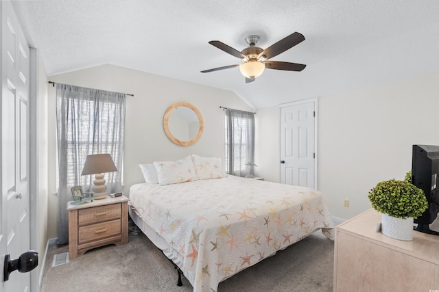 carpeted bedroom featuring vaulted ceiling, ceiling fan, and a textured ceiling