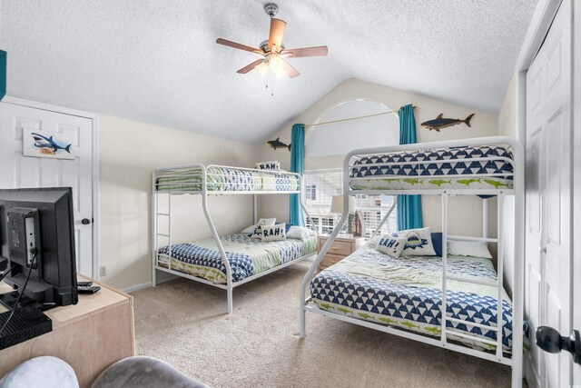 bedroom featuring ceiling fan, a textured ceiling, carpet flooring, and vaulted ceiling